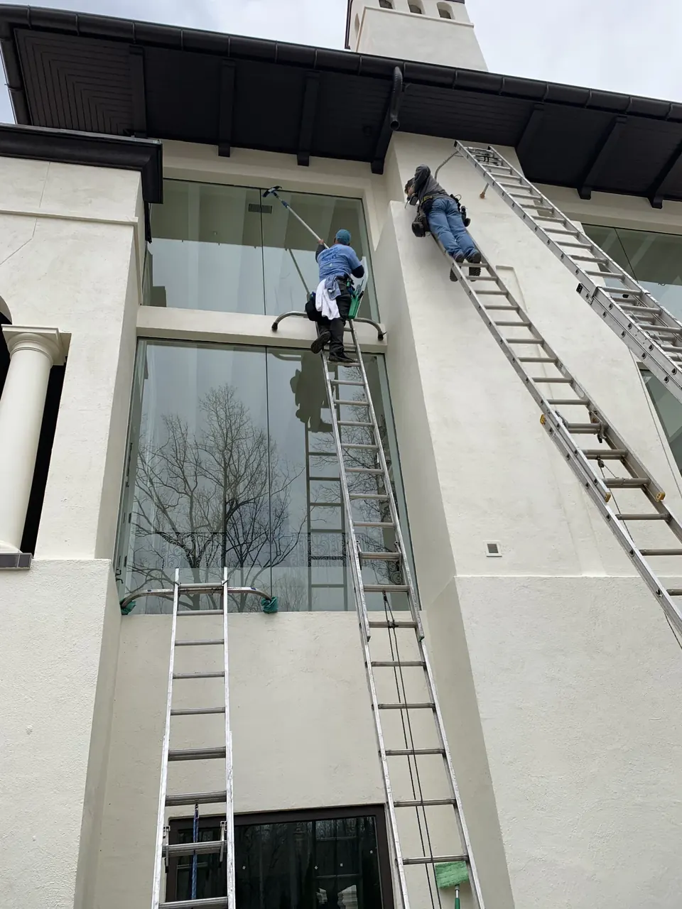 AAA technician cleaning tall residential windows in Charlotte, NC