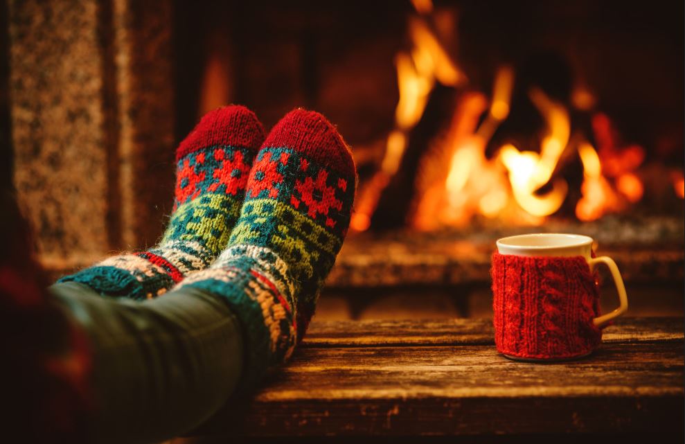 Feet staying warm by a fireplace