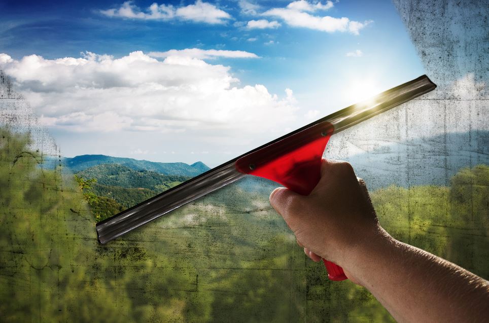 A dirty window being cleaned for spring.