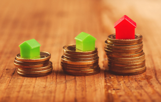 plastic houses on stacked coins